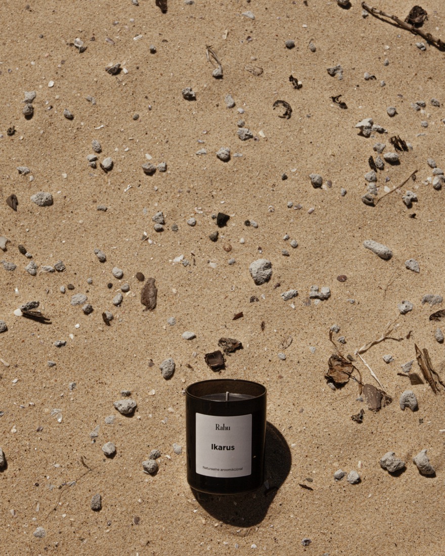 A Rahu Ikarus candle resting in coastal sand